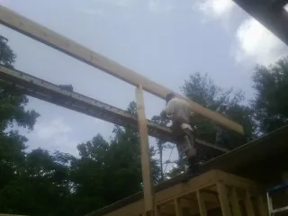 Carpenter setting a ridge beam over a new addition frame — Ice Dam Removal by Roofing Brothers in Judith Gap
