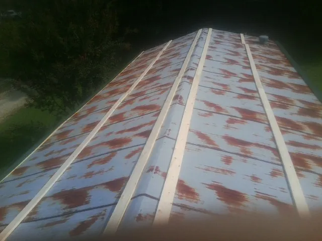 Rusted metal roof panels with new wood purlins before replacement — Storm Damage Roof Repair in Judith Gap by Roofing Brothers